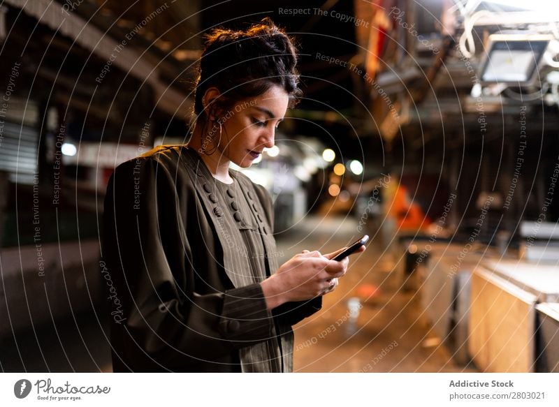 Stylische Dame mit Smartphone auf geschlossenem Markt bei Nacht Frau Stil PDA Schickimicki Tel Aviv Israel Straße Handy benutzend kleiner Laden trendy Entwurf
