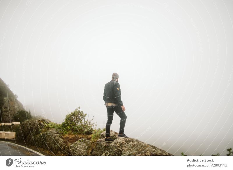 Anonymer Mann, der auf einer Klippe in der Nähe der Landstraße steht. Nebel Landschaft Straße Spanien playa norte Felsen Ferien & Urlaub & Reisen erkunden