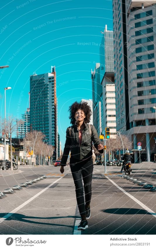 Frau mit Afrohaar geht durch die Straßen. Afrikanisch Amerikaner Tasche schön schwarz Business lässig Großstadt lockig Mode Mädchen Behaarung Glück Lifestyle