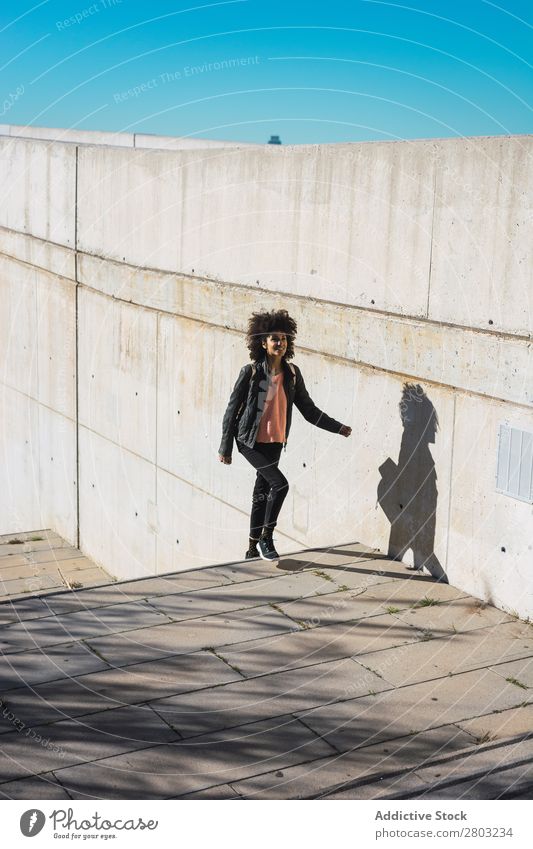 Eine schwarze Frau geht die Straße entlang. Afrikanisch Amerikaner attraktiv Tasche schön Körper lässig Solarzelle Handy Großstadt Mode voll Glück Halt
