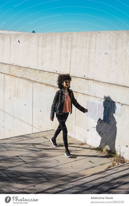 Eine schwarze Frau geht die Straße entlang. Afrikanisch Amerikaner attraktiv Tasche schön Körper lässig Solarzelle Handy Großstadt Mode voll Glück Halt