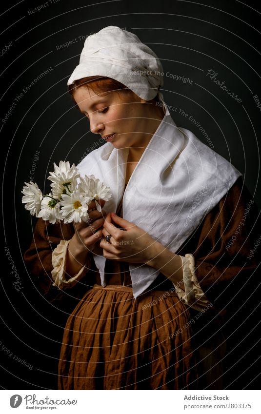 Mittelalterliches Dienstmädchen mit Blumen mittelalterlich rothaarig Frau Halt Margeriten Bekleidung historisch Kleid Kostüm Jungfer Motorhaube Renaissance