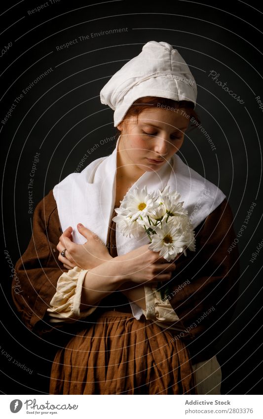 Mittelalterliches Dienstmädchen mit Blumen mittelalterlich rothaarig Frau Halt Margeriten Bekleidung historisch Kleid Kostüm Jungfer Motorhaube Renaissance