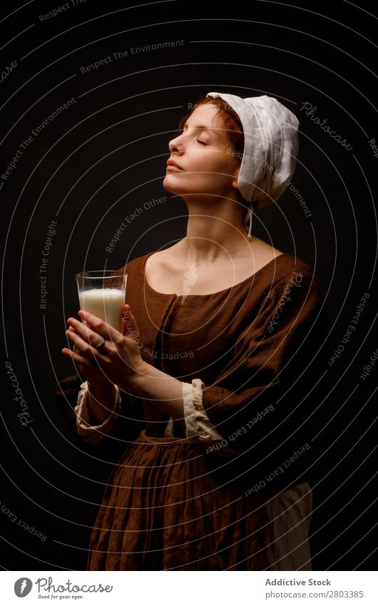 Mittelalterliches Dienstmädchen mit einem Glas Milch mittelalterlich rothaarig Frau geschlossene Augen Bekleidung historisch Kleid Kostüm Jungfer Motorhaube