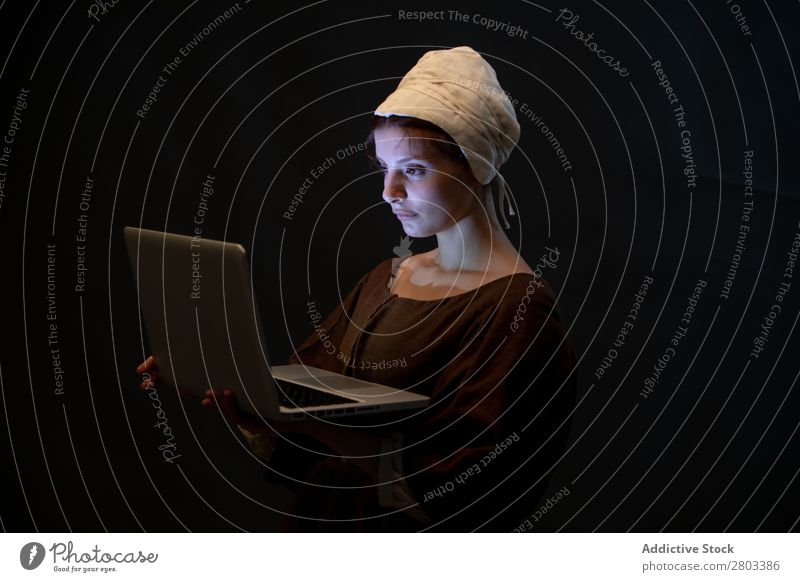Mittelalterliches Dienstmädchen mit Laptop mittelalterlich Notebook benutzend Entwurf Frau geschlossene Augen Bekleidung historisch Kleid Kostüm Jungfer