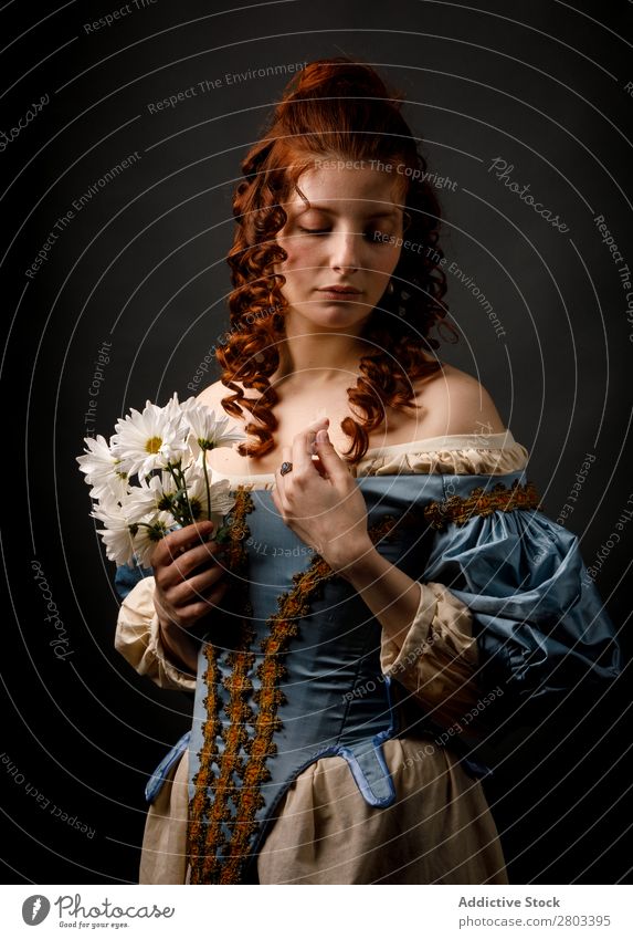 Barocke Frau mit geschlossenen Augen, die Blumen hält. rothaarig Korkenzieher geschlossene Augen Kleid mittelalterlich Karneval Renaissance Prinzessin Königlich