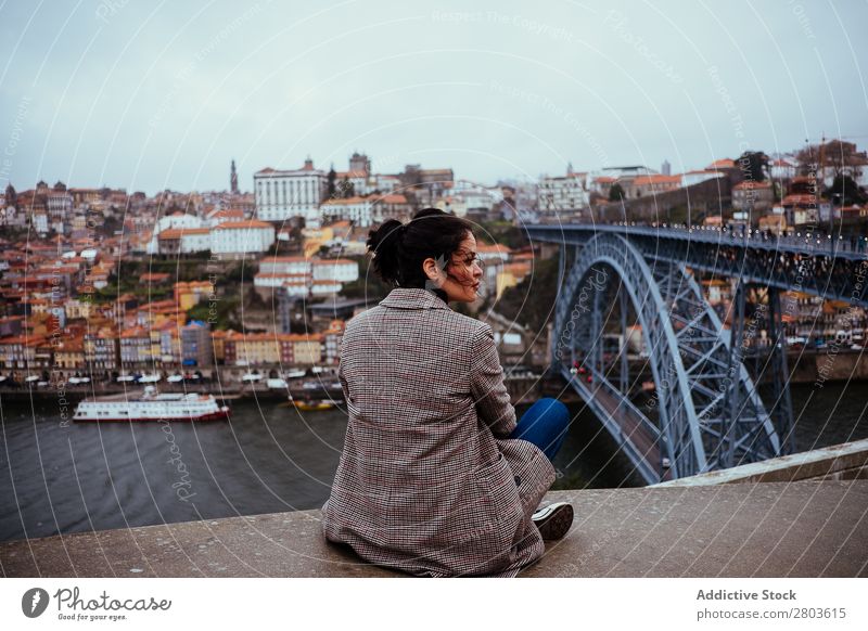 Stilvolle Frau, die an der Brücke in der Altstadt sitzt. Großstadt alt Tourismus Wegsehen sitzen Fluss Porto Portugal Stadt Straße Ferien & Urlaub & Reisen