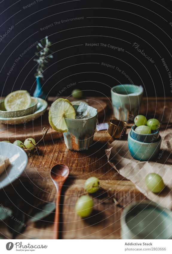 Anordnung des Keramikgeschirrs auf Holztisch Tisch Weintrauben Utensil Design rustikal frisch Zitrone Kunstgewerbler Frucht Platten Kreativität natürlich