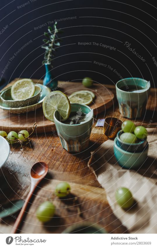 Anordnung des Keramikgeschirrs auf Holztisch Tisch Weintrauben Utensil Design rustikal frisch Zitrone Kunstgewerbler Frucht Platten Kreativität natürlich