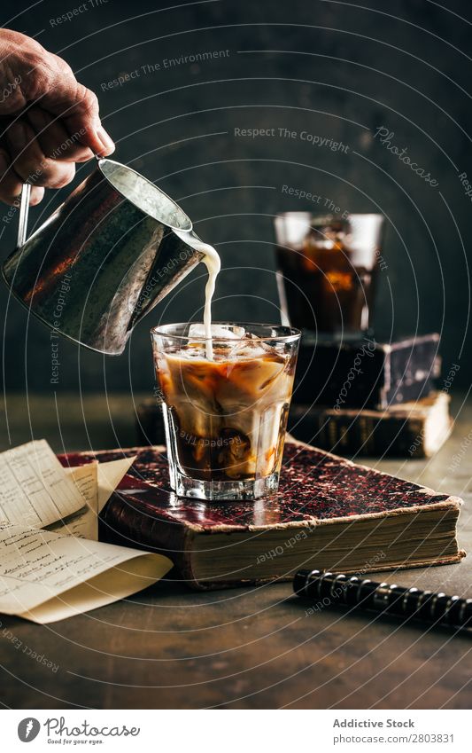 Gießen von Milch in ein kaltes Espressoglas Antiquität aromatisch Bohnen Getränk Buch Frühstück brauen braun Koffein Kaffee Kaffeepause Kaffeekanne Creme Tasse