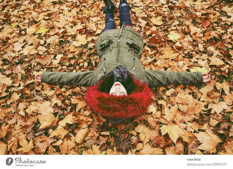 Junge brünette Frau legt sich über das Herbstlaub Lifestyle Stil Gesicht Gesundheit Wellness Wohlgefühl Erholung Windstille Freizeit & Hobby Mensch feminin