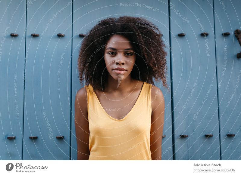 Wunderschöne schwarze Frau in Kleid auf der Straße. Tür lockig Stadt genießen blau Barfuß traumhaft urwüchsig Afroamerikaner Afro-Look Angebot Körper