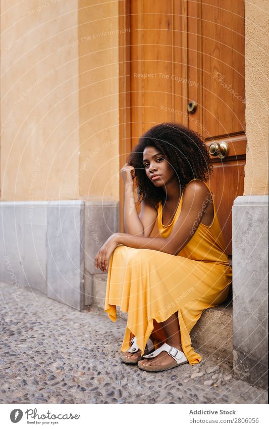 Wunderschöne schwarze Frau in Kleid auf der Straße. Tür lockig Stadt genießen Barfuß traumhaft urwüchsig Afroamerikaner Afro-Look Angebot Körper selbstbewußt