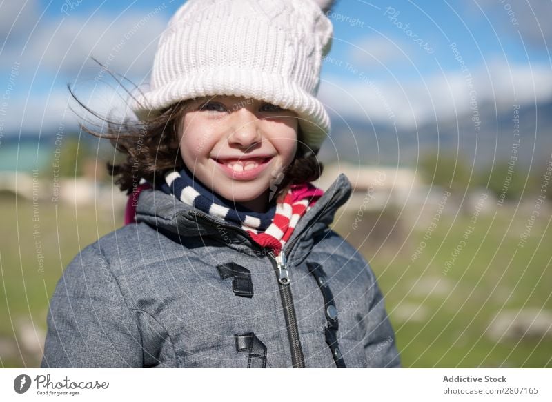 Nahaufnahme eines kleinen Mädchens mit Wollmütze und Schal auf dem Feld. Kind Porträt Hintergrundbild Wolle schön Außenaufnahme Hut Kaukasier Blick Mantel