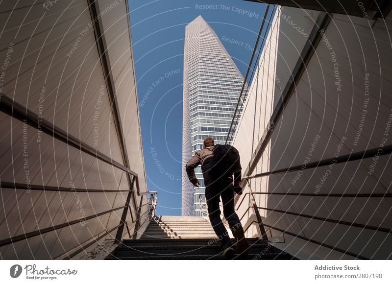 Mann steigt die Treppe zum Wolkenkratzer hinauf - 4 Büro Großstadt Hochhaus Mensch Außenseite modern Business Zentrum nach oben Madrid Erfolg Stadt Skyline