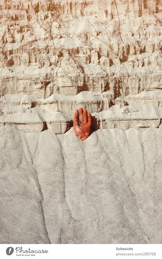 Hand im Sand Finger Umwelt Urelemente Küste Strand orange verschütten Demontage Halt stoppen gefährlich Risiko herausragen Handschuhe Steilwand Klippe