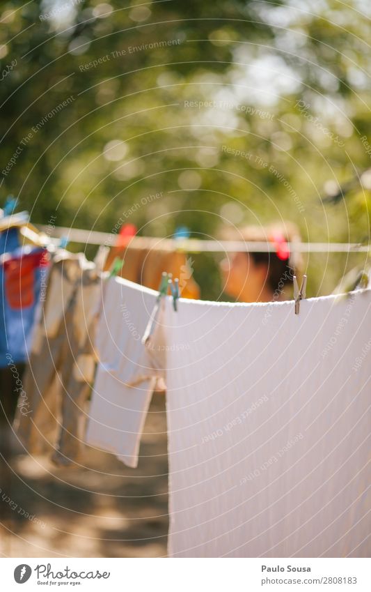 Frau trockene Kleidung im Freien Frühling Wäscheleine Lifestyle Kleiderhaken Wäscherei trocknen Haushalt Waschtag Farbfoto Außenaufnahme Bekleidung aufhängen