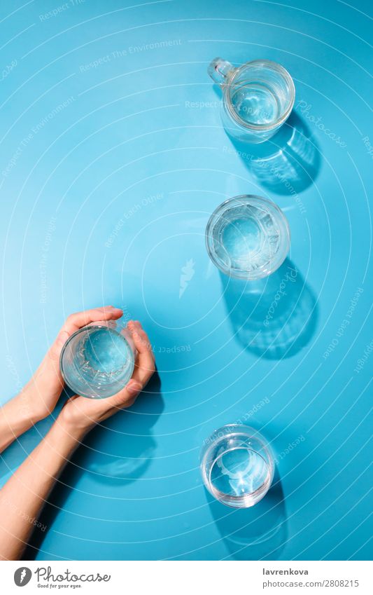 Die Hände der Frau halten eine Tasse sauberes Mineralwasser. frisch Sauberkeit Flasche Objektfotografie Getränk trinken kalt Sommer Glas Verschiedenheit