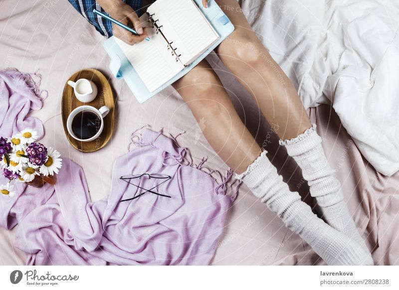 Flachlegen mit weiß gebräunter Frau in weißen Socken Brille gemütlich Winter Herbst flache Verlegung Hygge Bett Bettwäsche Getränk Decke Bettdecke Blumenstrauß