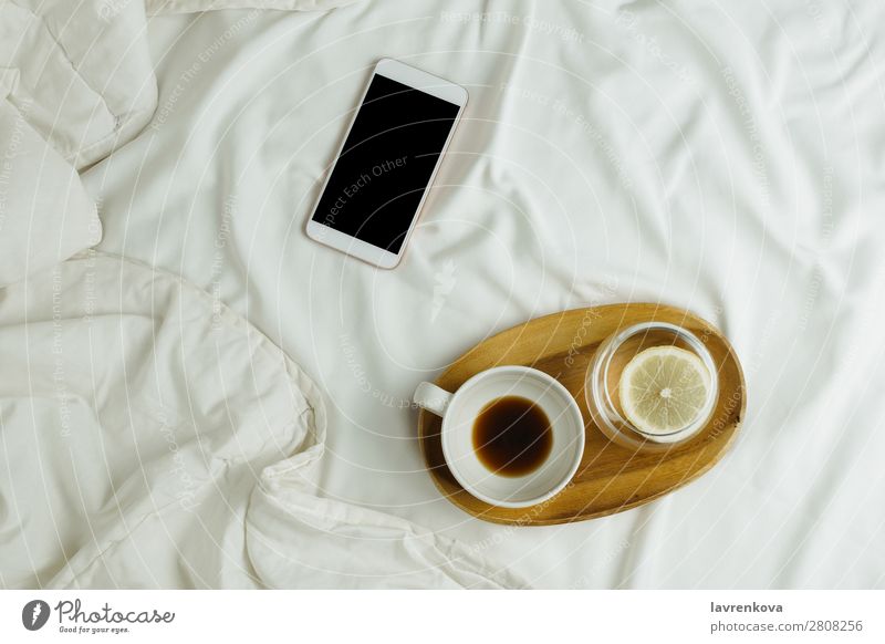 Tasse Kaffee und Zitronenwasser auf Holztablett und Smartphone Hintergrundbild Schlafzimmer Getränk schwarz Frühstück Business Zelle Verbindung Espresso