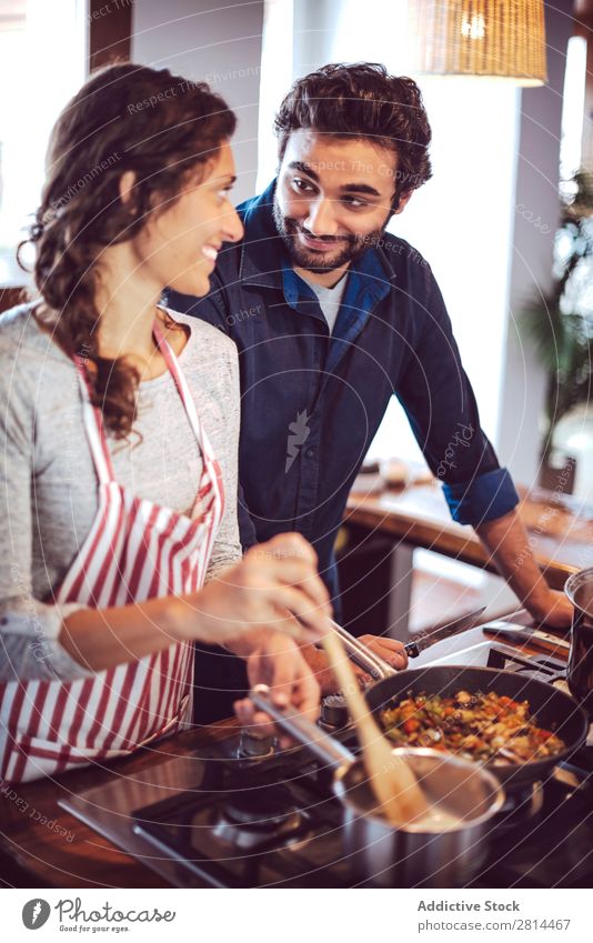 Junges Paar beim Kochen. Mann und Frau in der Küche kochen & garen heimwärts Abendessen Jugendliche Essen Ehefrau Erwachsene Lächeln Innenarchitektur Ehemann