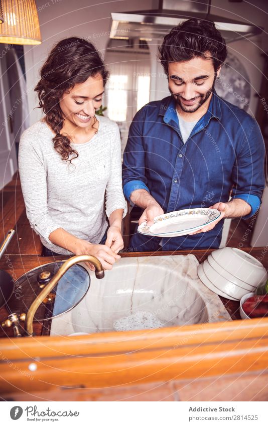 Junges Paar beim Geschirrspülen in der Küche Speise Waschen Mann Haushaltsführung Frau Seife Typ heimwärts heiß Sauberkeit Wasser Freude Partner Unterstützung