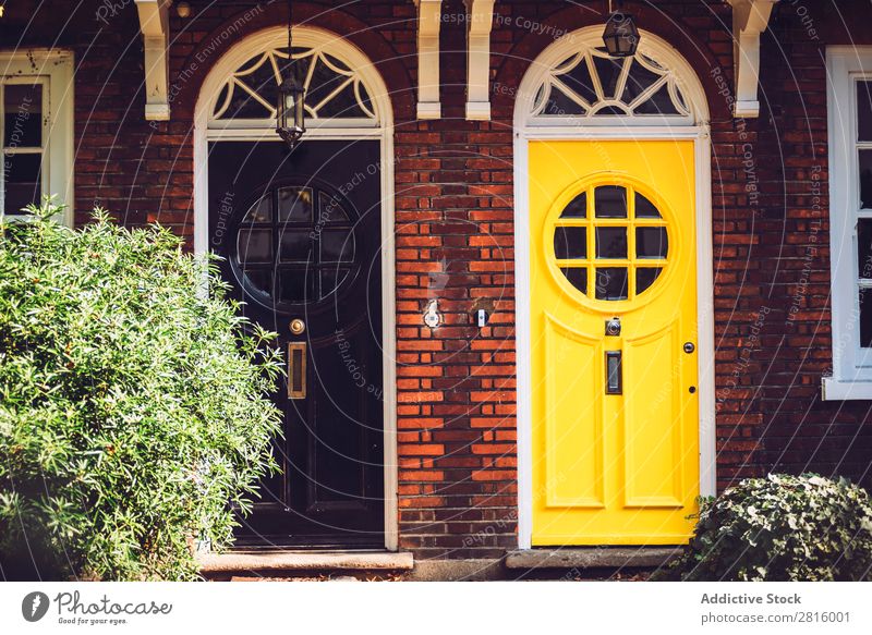Helle Vintage-Türen. altehrwürdig London hell schwarz gelb gestylt Eingangstür rund Fenster Glas Holz Farbe mehrfarbig Außenaufnahme Außenseite Vorderansicht