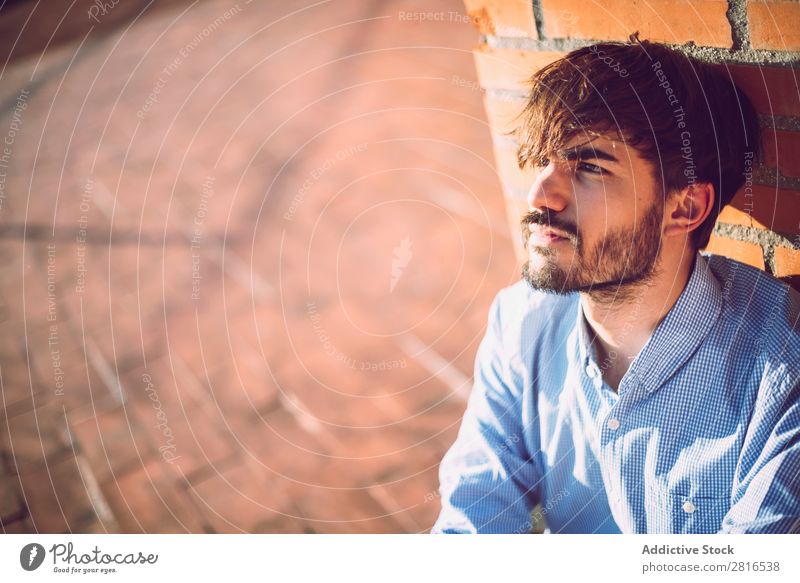 Gutaussehender kaukasischer junger Mann in Freizeitkleidung in städtischer Umgebung. Porträt Jugendliche Lächeln 20s Typ Coolness Außenaufnahme Leben Wand