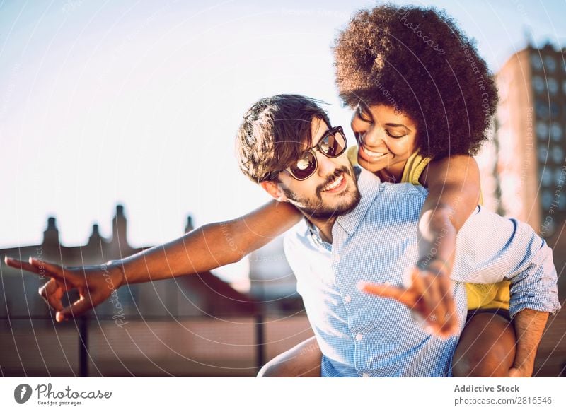 Interracial Paar mit Spaß auf dem Dach urwüchsig Jugendliche Rennsport Kaukasier Außenaufnahme Park Afroamerikaner Junge interrassisch umarmend Mensch Liebe