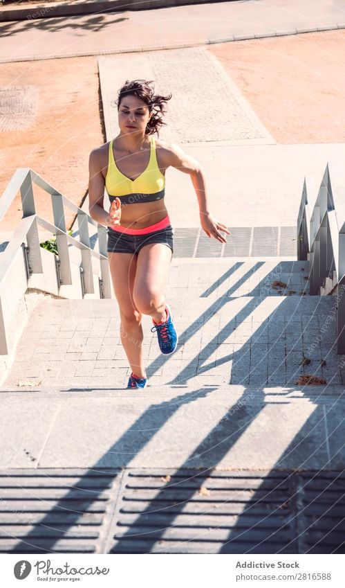 Athletische Frau, die während des Herz-Kreislauf-Trainings die Treppe hinaufläuft - Intervalltraining Fitness rennen Geschwindigkeit Außenaufnahme dünn schwer