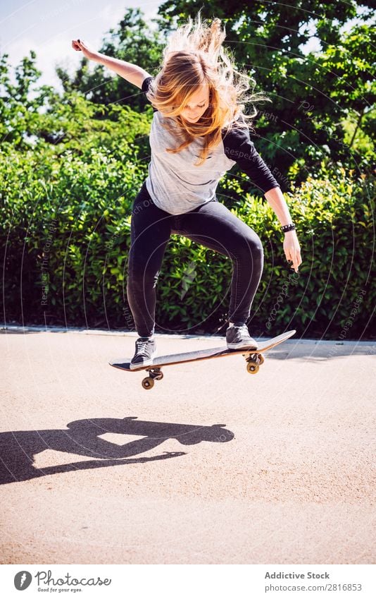 Skateboarderin, die Ollie im Park übt. asiatisch Aktion Außenaufnahme Sonnenlicht Rampe Skateboarding verpflichtet entschlossen Bewegung Mensch 1 Frau Energie