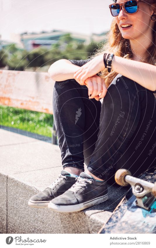Skateboardfrau, die in einem Park sitzt. Frau asiatisch Skateboarding Sonnenbrille Freude Hut Chinese Musik Stadt Kultur Mütze Außenaufnahme sitzen Fitness 1