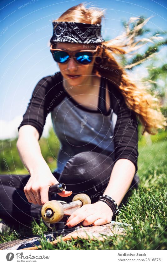 Junge Frau zieht Muttern in Lastwagen ihres Skateboards an. Schraube spannen Metall Zurücksetzen abstützen Objektfotografie Flugzeugwartung rostfrei
