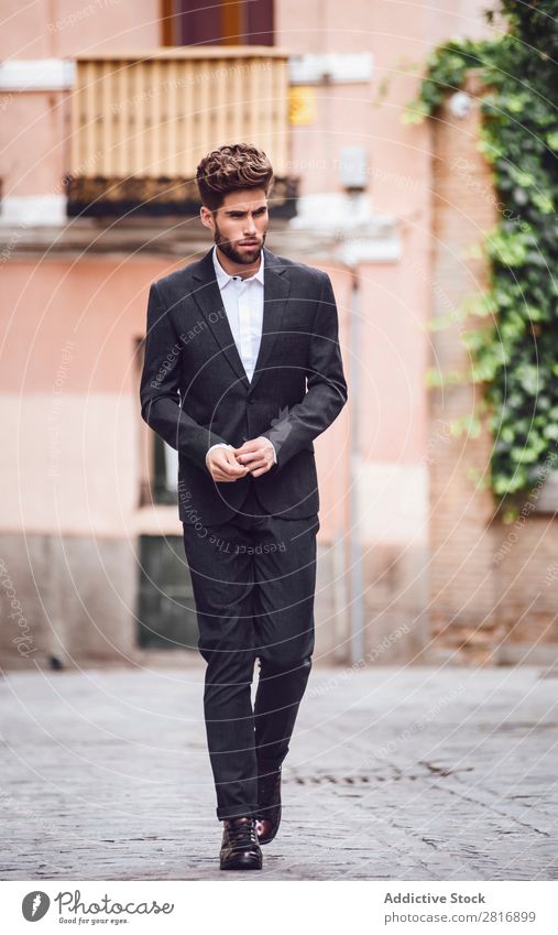 Schöner, eleganter Mann der jungen Mode im trendigen Kostümanzug, der die Straße entlanggeht. Anzug Herr modisch Bekleidung Stil Model Hemd Hand lässig modern