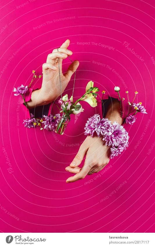 Hände durch Papierhalteflasche mit Blumenstrauß an einer Kette aromatisch schön Beautyfotografie Flasche Blütenknospen Entwurf Mode Frau Glamour Halt Schmuck