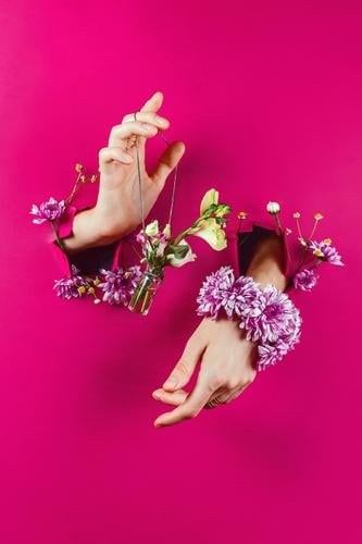 Hände durch Papierhalteflasche mit Blumenstrauß an einer Kette aromatisch schön Beautyfotografie Flasche Blütenknospen Entwurf Mode Frau Glamour Halt Schmuck