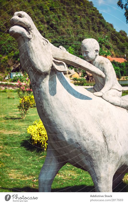 Statue eines kleinen Jungen mit einem Büffel Vietnam Außenaufnahme Thailand Haustier Wiese Park Säugetier Mensch Lächeln Asien Liebe Freundschaft rüstig Gesicht