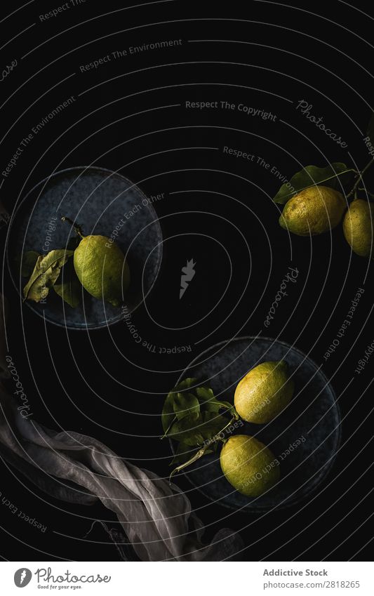 Frische, reife Zitrusfrüchte. Zitronen, Limetten auf dunklem Hintergrund Limone schwarz Hintergrundbild dunkel Frucht grün Textfreiraum Schiefer Menschengruppe