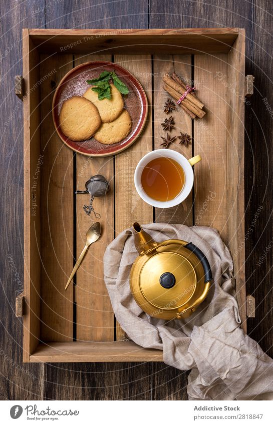Teekanne mit Tasse grünem Tee mit Minze Zimt Vogelperspektive Serviette trinken heiß Lebensmittel Kekse lecker Gesundheit natürlich Holz Holzkiste Nahaufnahme
