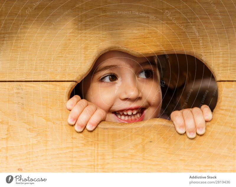 Eva Ozkoidi_girl schaut durch das Loch. Mädchen Kind Kinderpark Holzhaus Spielen Lächeln Glück Weihnachten & Advent Winter Kindheit Garten