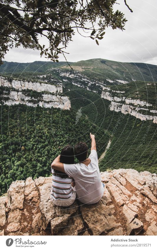 Ein Paar sitzt auf einer Klippe. Landschaft Natur Ferien & Urlaub & Reisen Felsen Abenteuer Mann Frau Freiheit Zusammensein Partnerschaft Jugendliche Liebe