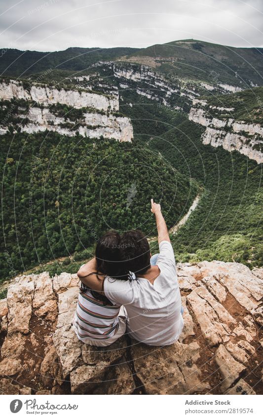 Ein Paar sitzt auf einer Klippe. Landschaft Natur Ferien & Urlaub & Reisen Felsen Abenteuer Mann Frau Freiheit Zusammensein Partnerschaft Jugendliche Liebe