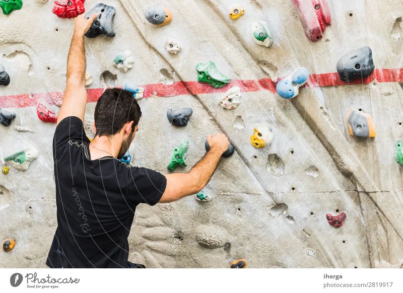 Ein Mann, der das Klettern an einer künstlichen Wand in Innenräumen übt. Lifestyle Freude Freizeit & Hobby Sport Bergsteigen Erwachsene Hand Finger 1 Mensch