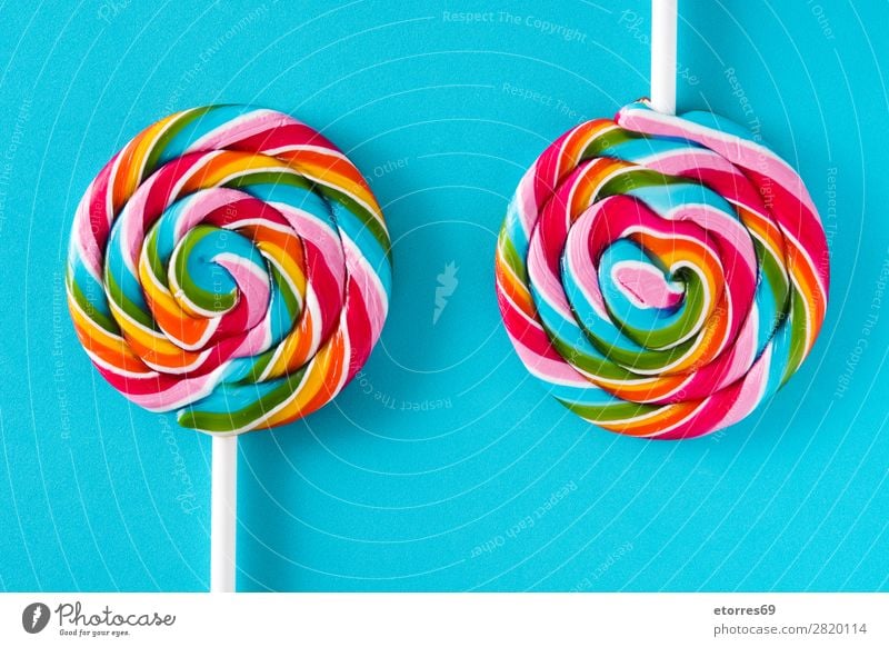 Bunte Lollis auf blauem Hintergrund. Draufsicht. Lollipop Farbe mehrfarbig Zucker Süßwaren Bonbon süß geschmackvoll Hintergrund neutral Hintergrundbild