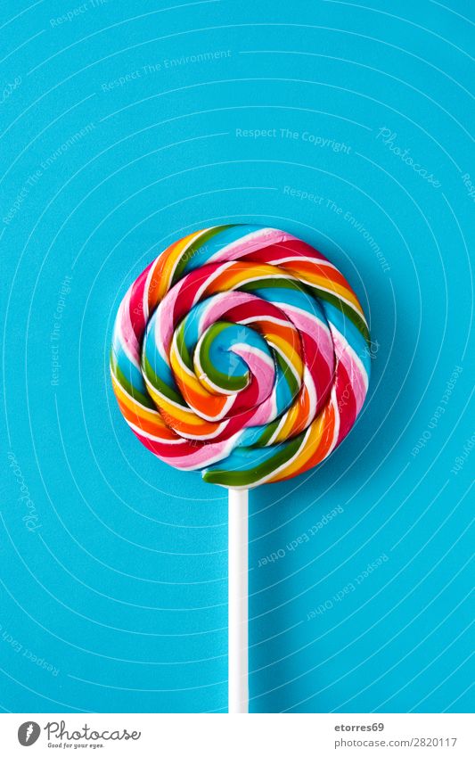 Bunte Lollis auf blauem Hintergrund. Draufsicht. Lollipop Farbe mehrfarbig Zucker Süßwaren Bonbon süß geschmackvoll Textfreiraum Lebensmittel Gesunde Ernährung