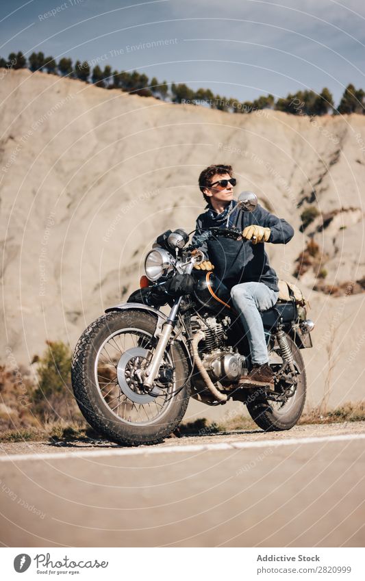 Mann auf dem Fahrrad schaut weg. Motorrad Coolness Wegsehen Straßenrand Motorradfahren Verkehr Sonnenbrille Fahrzeug Lifestyle Ferien & Urlaub & Reisen