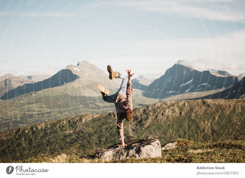 Mann, der in der Landschaft auf der Hand steht. Handstand Natur Berge u. Gebirge extrem Gleichgewicht Panorama (Bildformat) Sport Gesundheit natürlich Reisender