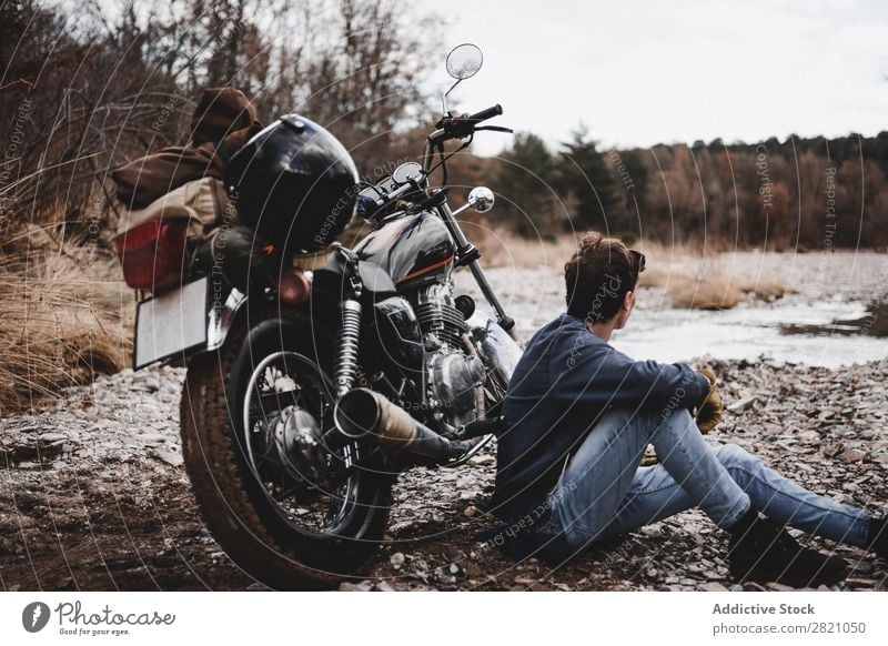 Mann sitzt in der Nähe des Motorrads Bach Verkehr Fahrzeug Freiheit Natur Offroad Wasser Fernweh Winter Körperhaltung Reisender selbstbewußt Erkundung