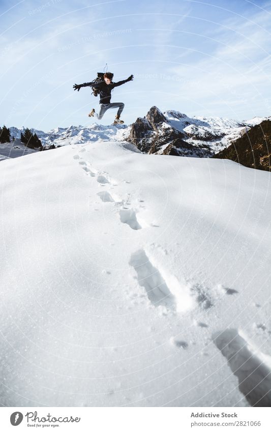 Ein Mann, der in den Schnee springt. Rucksacktourismus Berge u. Gebirge extrem Trekking wandern Schneefälle Abenteurer Altimeter Tourismus Jahreszeiten Sport