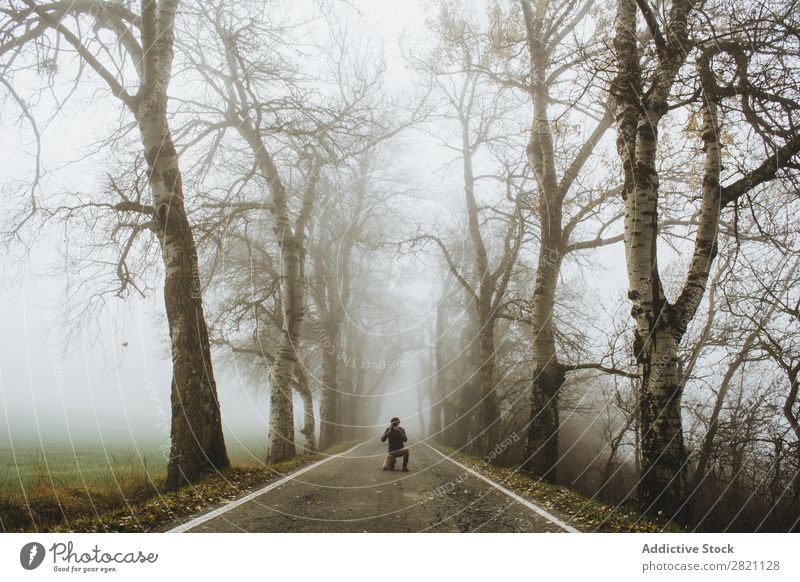Mann auf nebliger Straße stehend Wald Nebel Herbst Mensch Natur Asphalt Licht Landschaft Morgen Jahreszeiten Blatt schön Wetter Länder Park mehrfarbig elegant